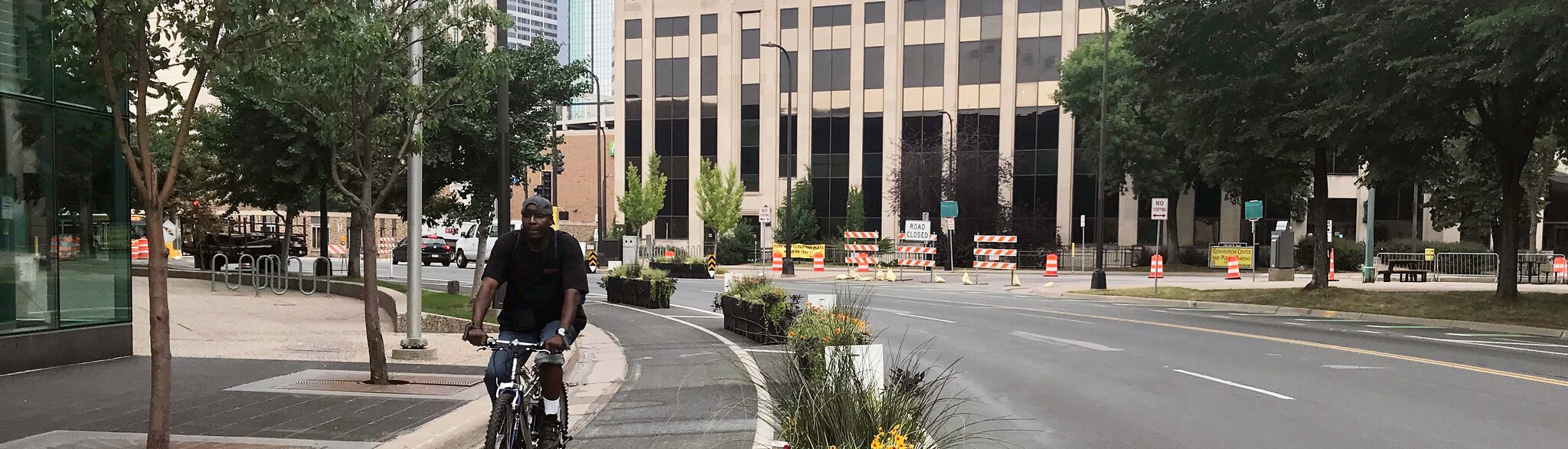 Person biking in a protected bike lane on a downtown Minneapolis street